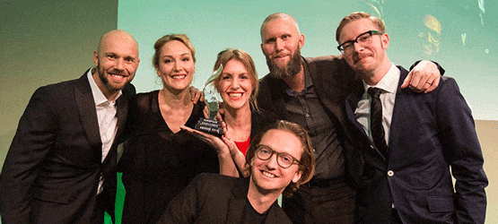 EEA_2016 Sechs Personen posieren lächelnd für ein Foto, eine hält einen Preis in der Hand, im Hintergrund eine Projektion.