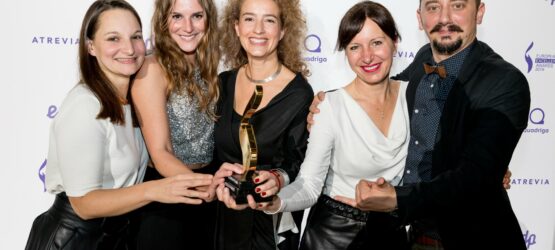 premios-43 Fünf Personen posieren lächelnd mit einem Preis vor einem beschrifteten Hintergrund.