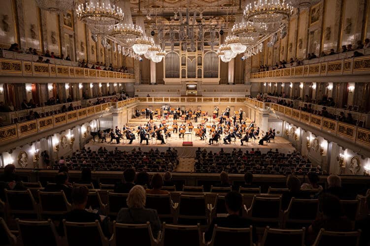 Orchesteraufführung im Konzerthaus Berlin mit Publikum in eleganter Umgebung und Kronleuchtern.