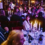 Elegante Award-Show mit Gästen an festlich gedeckten Tischen, Kerzenlicht und festlicher Atmosphäre.