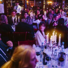 Elegante Award-Show mit Gästen an festlich gedeckten Tischen, Kerzenlicht und festlicher Atmosphäre.