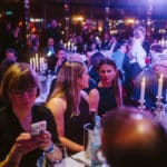 Menschen in eleganter Kleidung sitzen an festlich gedeckten Tischen bei der European Excellence Awards 2025.