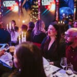 Elegante Award-Show mit Gästen an festlich gedeckten Tischen, Kerzenlicht und festlicher Dekoration im Hintergrund.