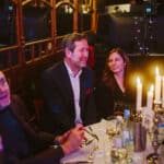 Gäste sitzen an einem Tisch bei der European Excellence Awards, umgeben von Kerzen und festlicher Dekoration.