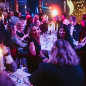 Elegante Award-Show mit Gästen an festlich gedeckten Tischen, Kerzenlicht und festlicher Atmosphäre.
