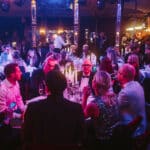 Elegante Award-Show mit Gästen an Tischen, Kerzenlicht und festlicher Atmosphäre in einem stilvollen Veranstaltungsort.