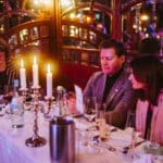 Elegantes Dinner-Setting mit Kerzenlicht, Gästen in formeller Kleidung und festlicher Atmosphäre während der European E...